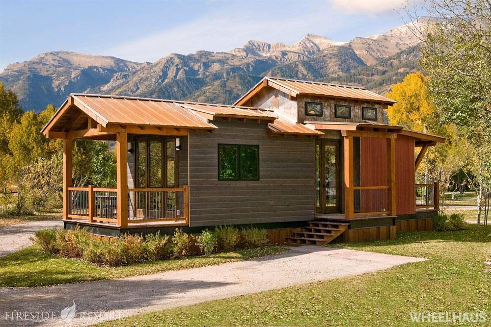 A cabin with a wide porch and glass front