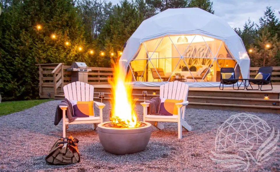 A fire pit in front of a lit dome